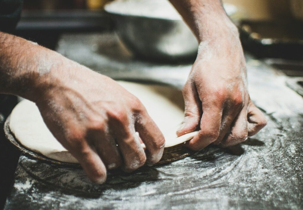 a person is kneading dough on a table